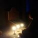 Anggota DPRD Kabupaten Gumas, Iceu Purnamasari saat menyalakan lilin di kuburan orang tuanya, di Kelurahan Kuala Kurun, Jumat (2/4/2021). (Foto : Iceu Purnamasari)