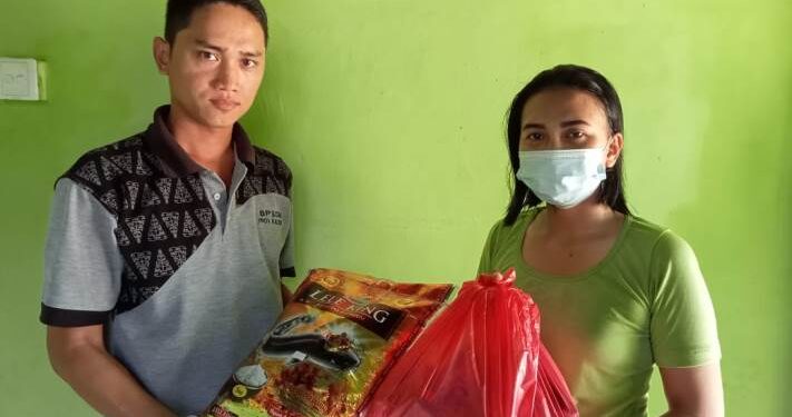 Perwakilan HRD PT HPL saat membagikan paket sembako ke salah satu penerima sembako di sekitar pabrik, Selasa, (13/4/2021). (Foto : IST)