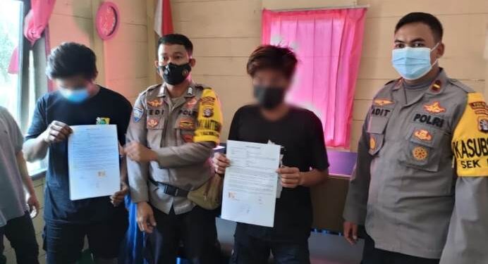 Kapolsek Kurun Ipda Aditya Arya Nugroho (kanan) didampingi Bhabinkamtibmas Brigpol Bedi (kiri kedua) mendamaikan An (kanan kedua) dan Ye (kiri), di Mapolsek Kurun, Rabu (28/4/2021). (Foto : Polsek Kurun)