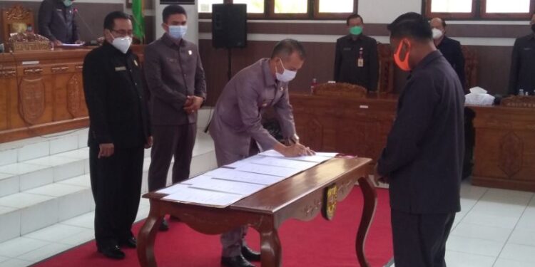 Bupati Gumas Jaya S Monong disaksikan Ketua DPRD Akerman Sahidar dan Wakil Ketua I Binartha menandatangani persetujuan bersama terkait empat buah raperda dan rancangan KUA-PPAS tahun 2022, saat rapat paripurna di Kuala Kurun, Selasa (27/7/2021). (IST)