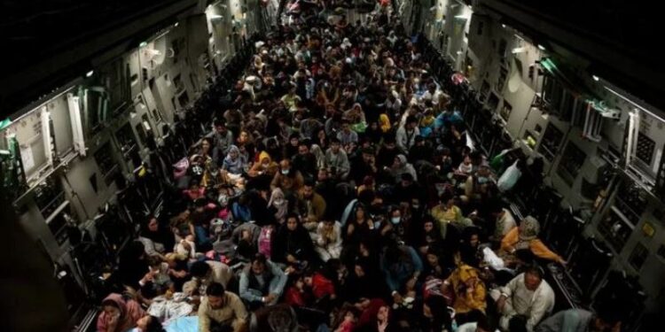 Warga yang dievakuasi dari Afghanistan duduk di dalam pesawat militer selama evakuasi dari Kabul, dalam foto yang diambil Kamis (19/8/2021) di lokasi tak disebutkan dan dirilis pada Jumat (20/8/2021). (ANT/Staff Sgt. Brandon Cribelar/U.S. Marine Corps/HO via Reuters)