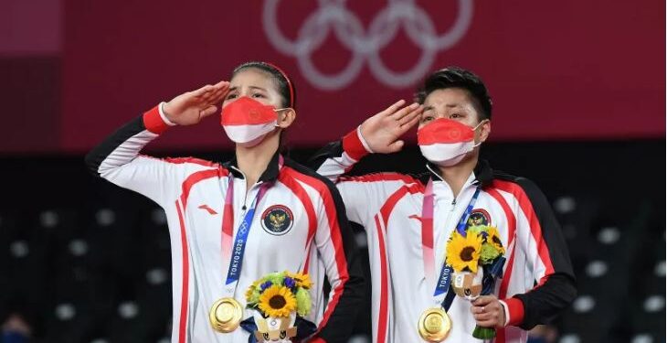 Pebulutangkis ganda Putri Indonesia peraih medali emas Greysia Pollii/Apriyani Rahayu hormat saat pengibaran bendera Merah-Putih usai menjuarai final Olimpiade Tokyo 2020 di Musashino Forest Sport Plaza, Tokyo, Jepang, Senin (2/8/2021). (ANT/IST)