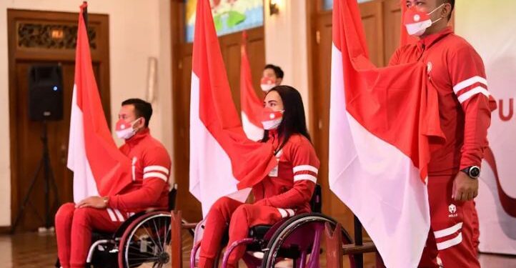 Atlet National Paralympic Committee (NPC) balap kursi roda Zaenal Arifin (kiri), angkat berat Ni Nengah Widiasih (tengah) dan menembak Bolo Triyanto (kanan) memegang bendera saat acara Pengukuhan dan Pelepasan Atlet NPC di Hotel Kusuma Sahid, Solo, Jawa Tengah, Sabtu (14/8/2021). NPC Indonesia akan memberangkatkan 23 atlet dari tujuh cabang olahraga pada pesta olahraga penyandang disabilitas dunia Paralimpiade Tokyo 2020. ANT/IST/HO-NPC Indonesia/yud/hp.