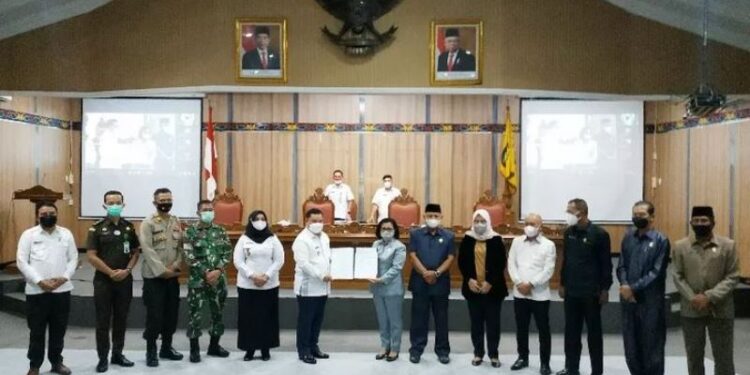 Bupati Halikinnor dan Ketua DPRD Rinie menunjukkan berita acara persetujuan KUPA-PPAS perubahan APBD tahun anggaran 2021 yang baru mereka tanda tangani bersama dalam rapat paripurna, Rabu (18/8/2021). (ANT)