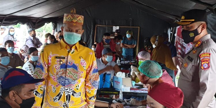 Bupati Gumas Jaya S Monong (batik kuning) bersama Kapolres Gumas AKBP Irwansah memantau pelaksanaan vaksinasi serentak di Taman Kota Kuala Kurun, Kecamatan Kurun, Kamis (5/8/2021). (Foto : Pemkab Gumas)