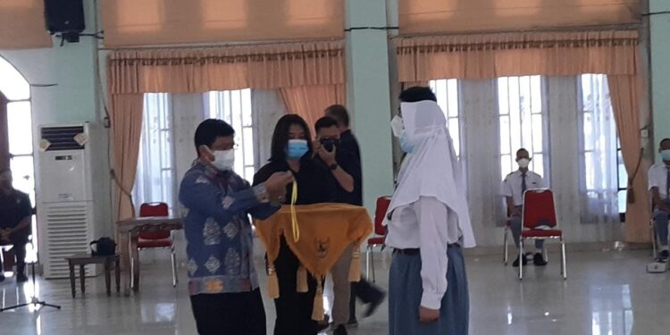 Kepala Disdikpora Kabupaten Gumas Esra bersiap mengalungkan tanda peserta kepada calon anggota Paskibraka, di GPU Damang Batu Kuala Kurun, Kamis (5/8/2021).