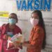 Ketua DPK PPNI RSUD Kuala Kurun Sriwani Yupita Rina (kanan) menyerahkan undian doorprize kepada masyarakat yang beruntung, saat pelaksanaan vaksinasi di RSUD Kuala Kurun, Kamis (5/8/2021). (Foto : PPNI Kabupaten Gumas)