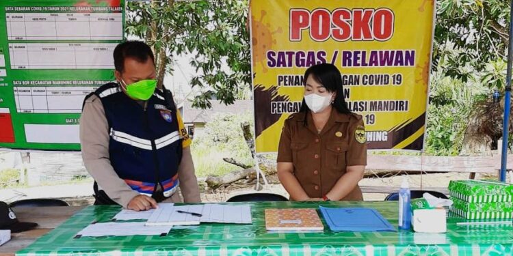 Ketua Relawan Satgas Covid-19 Kecamatan Manuhing, Gusti Ray Novhandha (kanan) dan anggota Polsek Manuhing saat beraktivitas di wilayah setempat, baru-baru ini. (MASAPNEWS/Dokumentasi pribadi)