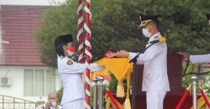 Bupati Gumas, Jaya S Monong menyerahkan Sang Saka Merah Putih kepada anggota Paskibraka untuk dikibarkan.