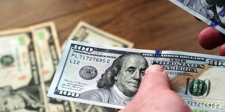 Petugas sedang menghitung uang 100 dolar AS. (Valera Golovniov/SOPA Images/S via Reuters Connect/pri/ANT)