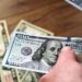 Petugas sedang menghitung uang 100 dolar AS. (Valera Golovniov/SOPA Images/S via Reuters Connect/pri/ANT)