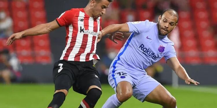 Penyerang Barcelona Martin Braithwaite (kanan) sedang berebut bola dengan pemain Athletic Bilbao Alejandro Berenguer dalam pertandingan Liga Spanyol di San Mames, Bilbao, Spanyol pada 21 Agustus 2021. (ANT/AFP/ANDER GILLENEA)