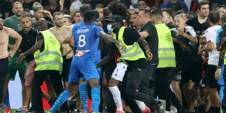 Petugas keamanan berusaha mencegah suporter yang berusaha menduduki lapangan dalam laga Liga Prancis antarfa OGC Nice dan Olympique de Marseille di Stadion Allianz Riviera di Nice, Prancis, 22 Agustus 2021. (AFP/VALERY HACHE)