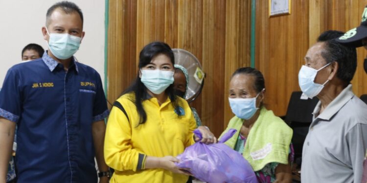 Bupati Gumas (kiri) Jaya S Monong mendampingi Ketua TP PKK Kabupaten Gumas Mimie Mariatie Jaya S Monong saat menyalurkan bantuan paket bahan pokok kepada warga Sarerangan dan Tumbang Pajangei, Kamis (9/10/2021). (Foto : Diskominfosantik Kabupaten Gumas)