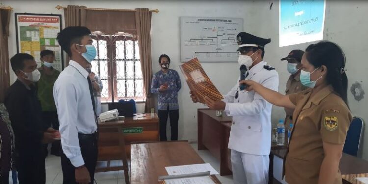 Kades Dahian Tambuk, Pendi mengambil sumpah janji Lepri Riadi sebagai Kaur Umum dan Perencanaan, di kantor desa setempat, Senin (13/9/2021). (MASAPNEWS/GCM)