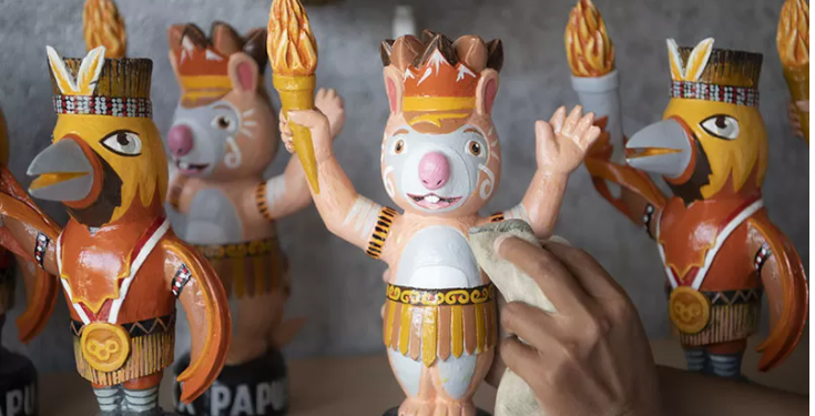 Karyawan membersihkan suvenir maskot PON Papua Kangpho dan Drawa dipusat oleh-oleh Abepura, Kota Jayapura, Papua, Kamis (30/9/2021). Suvenir yang terbuat dari kayu susu (Alstonia scholaris (L.) R.Br.) dan fiberglass tersebut dijual dengan harga Rp300 ribu per buah. ANT/ISTi.