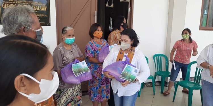 Ketua PWKI Kabupaten Gumas Rayaniatie Djangkan menyalurkan bingkisan kasih kepada warga kurang mampu dan lansia yang terdampak banjir, di Desa Tumbang Hakau, Kecamatan Kurun, Sabtu (18/9/2021). (MASAPNEWS/GCM)