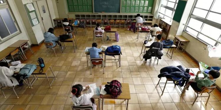 Para murid duduk berjauhan saat belajar di sekolah dasar Nagoya, Jepang. (REUTERS/KYODO/ANT)