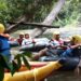 Para wisata arung jeram saat menikmati keindahan sungai dan hutan tropisnya masih hijau.