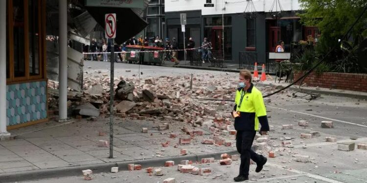 Seorang warga berjalan melewati reruntuhan bagian depan sebuah restoran di Windsor, Melbourne, Australia, setelah gempa mengguncang kota pinggiran Melbourne itu pada Rabu (22/9/2021). (MASAPNEWS/AAP Image/James Ross via REUTERS/STRINGER/ANT)