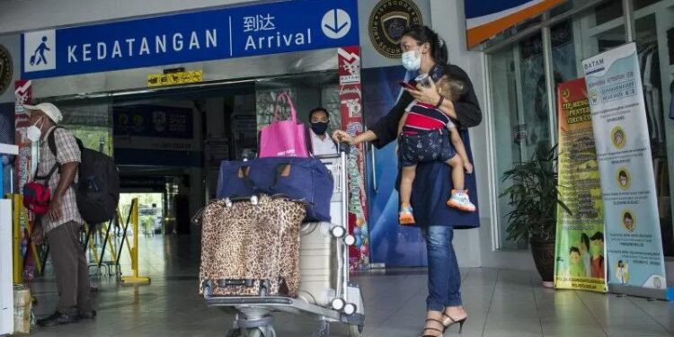 Pekerja migran berada didekat pintu kedatangan Pelabuhan Internasional Batam Centre, Batam, Kepulauan Riau, Senin (26/10/2020). (MASAPNEWS/ANT)