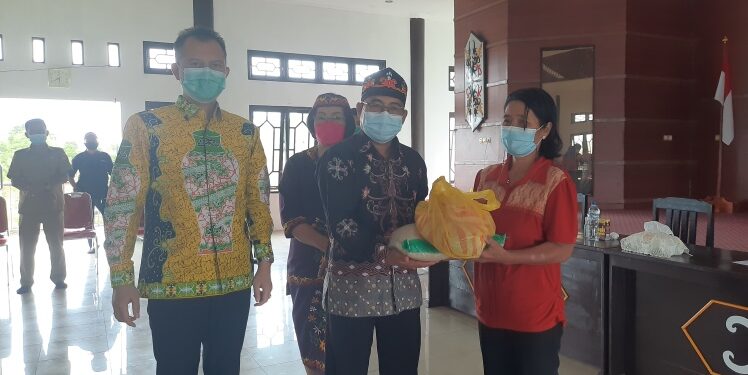 Ketua DAD Kabupaten Gumas Jaya S Monong dan Wakil Ketua Efrensia L.P Umbing mendampingi Ketua Harian Herbert Y Asin yang menyalurkan bantuan secara simbolis kepada lansia terdampak banjir, di kantor DAD setempat, Senin (4/10/2021). (MASAPNEWS/GCM)