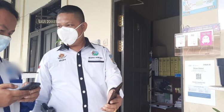 Kasatresnarkoba Polres Gumas Ipda Budi Utomo (kanan) memandu warga menggunakan aplikasi Peduli Lindungi sebelum memasuki wilayah Mapolres setempat, Rabu (13/10/2021). (MASAPNEWS/GCM)