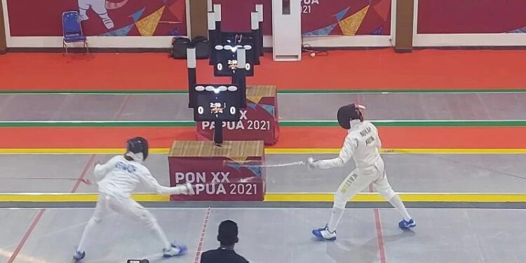 Atlet Riau Nisa Aprawasih (kiri) saat bertanding melawan atlet Kalimantan Timur Anis Rohdatul Niehlah (kanan) dalam final cabang olahraga anggar nomor degen individual pputri PON XX Papua di Gedung Serbaguna Gereja St Yoseph, Merauke, Selasa (5/10/2021). (MASAPNEWS/ANT)