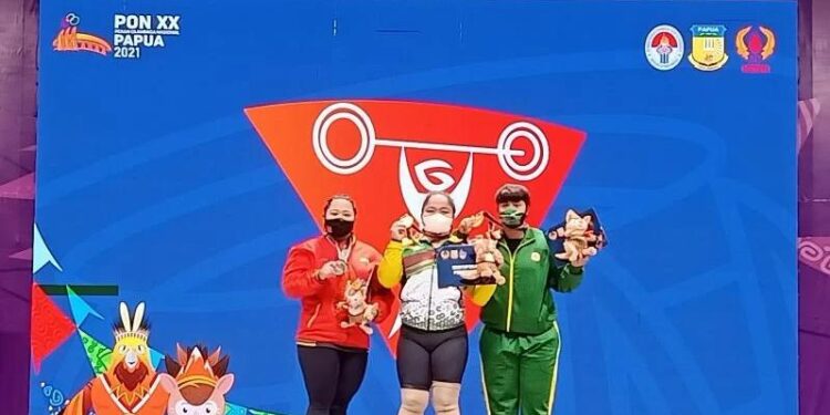 Lifter putri Maharani (tengah) berpose di podium kemenangan cabang angkat besi putri kelas 87 kg PON XX Papua di Auditorium Uncen Jayapura, Papua, Sabtu (9/10/2021). (MASAPNEWS/ANT)