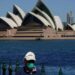 Seorang warga berjalan di tepi pelabuhan di seberang Sydney Opera House selama penguncian COVID-19 di Sydney, Australia, Rabu (6/10/2021). (MASAPNEWS/ANT/Reuters)