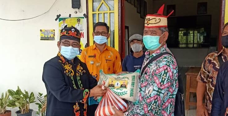 Ketua Harian DAD Kabupaten Gumas, Herbert Y Asin (kiri) menyalurkan bansos di Kedamangan Kahut, Kamis (7/10/2021). (Foto : DAD Kabupaten Gumas)