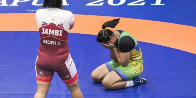 Pegulat putri Jatim Varadisa (kanan) melakukan selebrasi usai mengalahkan pegulat putri Jambi Indri (kiri) pada final Gulat Gaya Bebas kelas 76 Kg PON Papua di Gor Futsal Dispora, Kabupaten Merauke, Papua, Minggu (10/10/2021). (MASAPNEWS/ANT)