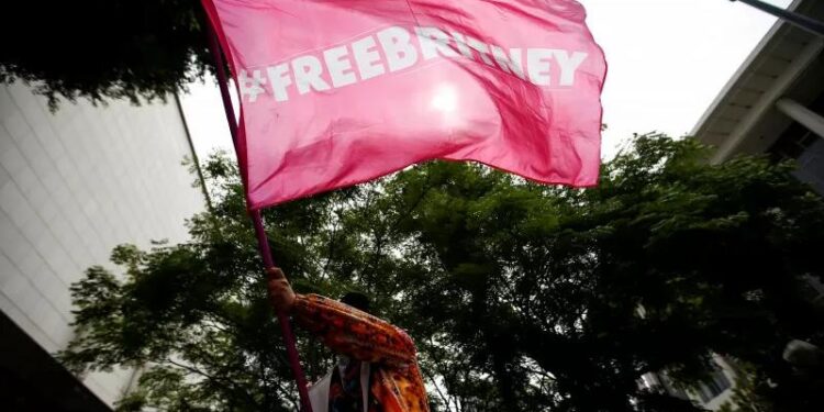 Seseorang melambaikan bendera Britney Spears di Stanley Mosk Courthouse, Los Angeles, California, Amerika Serikat (26/7/2021). (REUTERS/Mario Anzuoni)