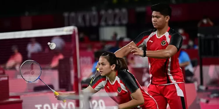 Praveen Jordan melakukan pukulan di samping pasangannya Melati Daeva Oktavianti (tengah) di pertandingan penyisihan grup bulu tangkis ganda campuran saat mereka melawan Simon Wing Hang Leung dan Gronya Somerville dari Australia pada Olimpiade Tokyo 2020 di Musashino Forest Sports Plaza di Tokyo, Jepang (24/7/2021). (MASAPNEWS/ANT/AFP)