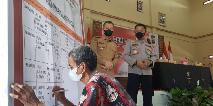 Bupati Gumas, Jaya S Monong didampingi Kapolres AKBP Irwansah melihat calon kades menandatangani pakta integritas usai melakukan deklarasi damai, di Kuala Kurun, Selasa (9/11/2021). (MASAPNEWS/GCM)