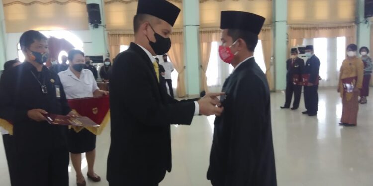 Bupati Gumas, Jaya S Monong (kiri) sematkan penghargaan kepada salah satu PNS, di GPU Damang Batu Kuala Kurun, Rabu (10/11/2021). (Foto : Diskominfosantik Kabupaten Gumas)