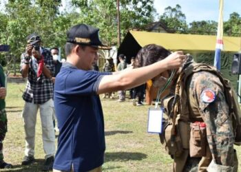 Wabup Lamandau Riko Porwanto saat menyempatkan tanda peserta kepada salah satu peserta Lamandau Milsim 2021, kemarin.