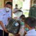 Kadis Sosial Gumas Jhonson Ahmad saat menyerahkan bansos kepada anak sekolah SD di Kelurahan Tumbang Marikoi Kecamatan Damang Batu, Rabu (17/11/2021) kemarin. (IST)