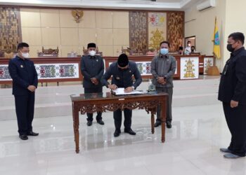 Bupati H Hendra! Lesmana saat mendatatangni berita acara persetujuan Raperda APBD 2022 pada sidang Paripurna, Senin (29/11/2021).