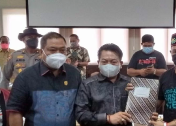 Koordinator aksi damai Aliansi Masyarakat Kabupaten Gunung Mas Yepta Diharja (kanan) menyerahkan tuntutan pihaknya kepada Ketua DPRD Kalteng Wiyatno didampingi para anggota di ruang rapat gabungan DPRD Kalteng, Kamis (16/12/2021). ANT/IST