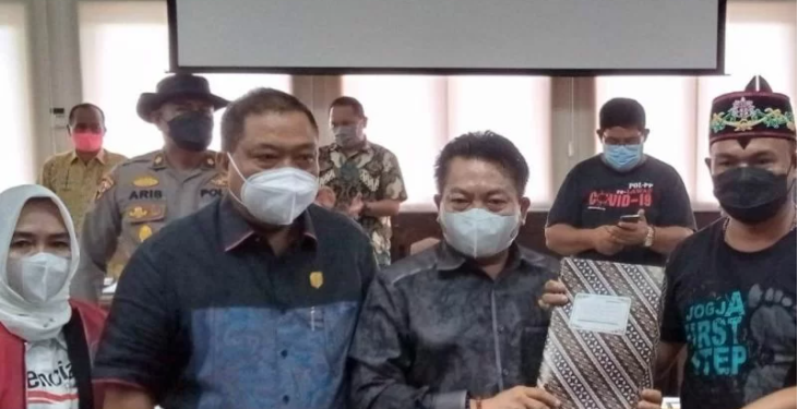 Koordinator aksi damai Aliansi Masyarakat Kabupaten Gunung Mas Yepta Diharja (kanan) menyerahkan tuntutan pihaknya kepada Ketua DPRD Kalteng Wiyatno didampingi para anggota di ruang rapat gabungan DPRD Kalteng, Kamis (16/12/2021). ANT/IST