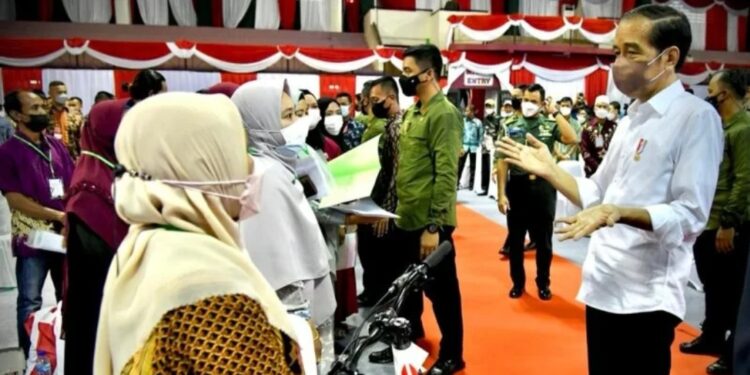 Presiden Joko Widodo membagi-bagikan sepeda kepada masyarakat yang berhasil menjawab pertanyaan dengan benar di Gedung Tenis Tertutup Telaga Keramat, Kota Tarakan, Provinsi Kalimantan Utara pada Selasa (21/12/2021). (MASAPNEWS/ANT/Laily Rachev - Biro Pers Sekretariat Presiden)
