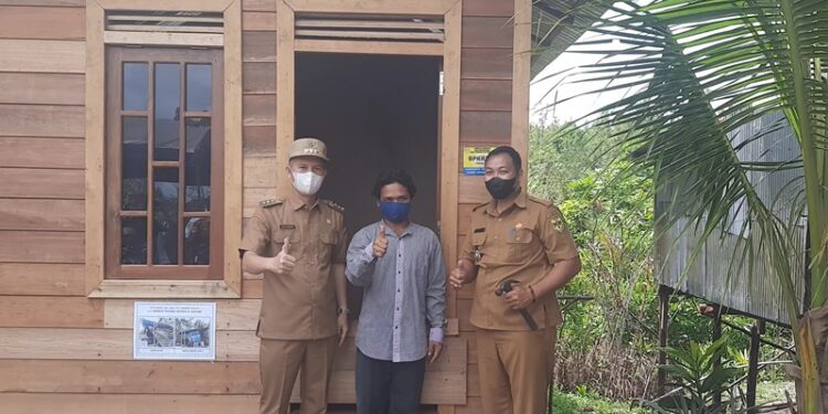 Bupati Gumas Jaya S Monong (kiri) bersama Lurah Tampang Tumbang Anjir Berjoaldi (kanan) dan warga penerima bantuan. (GCM/MN-2)