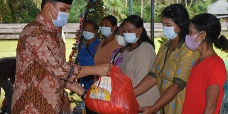 Bupati Kabupaten Lamandau saat memberikan bingkisan kepada warga yang ikut merayakan natal bersama di desa Toka, kemarin.