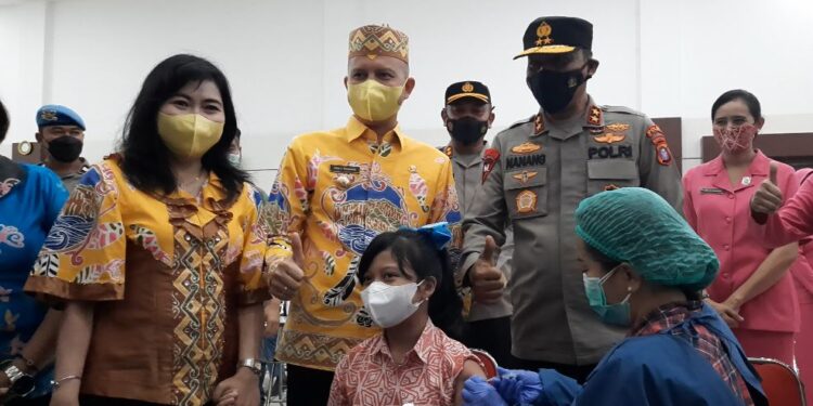 Bupati Gumas Jaya S Monong dan istri Mimie Mariatie Jaya S Monong mengantarkan buah hati mereka Ester Gloria untuk mengikuti vaksinasi Covid-19 di Gedung Christian Center Kalawa Kuala Kurun, Kamis (20/1/2022). Kapolda Kalteng Irjen Pol Nanang Avianto dan jajaran turut menyaksikan vaksinasi ini. (MASAPNEWS/GCM)