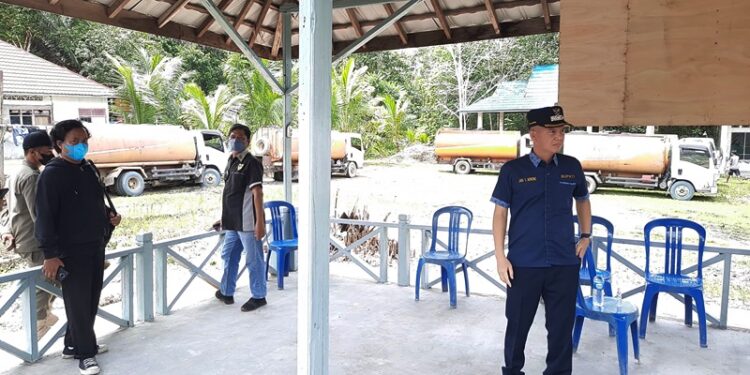 Bupati Gumas Jaya S Monong (kanan) memantau penahanan truk-truk angkutan PBS yang bandel masih melintas di ruas jalan Palangka Raya-Kuala Kurun di wilayah setempat. Penahanan dilakukan di pos di Desa Sepang Kota, Kecamatan Sepang, Jumat (21/1/2022). (MASAPNEWS/GCM)