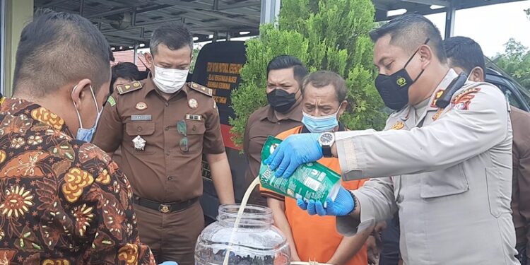 Kapolres Gumas AKBP Irwansah dan lainnya memusnahkan sabu dengan cara dilarutkan ke dalam air bersama deterjen, di Mapolres setempat, Kamis (27/1/2022). (MASAPNEWS/GCM)