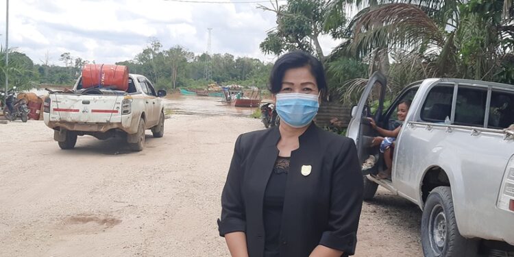 Wakil Ketua Komisi III DPRD Gumas Lily Rusnikasi sesaat sebelum menggunakan jasa feri penyeberangan di Kelurahan Sepang Simin, Kecamatan Sepang, Senin (14/2/2022). (MASAPNEWS/GCM)