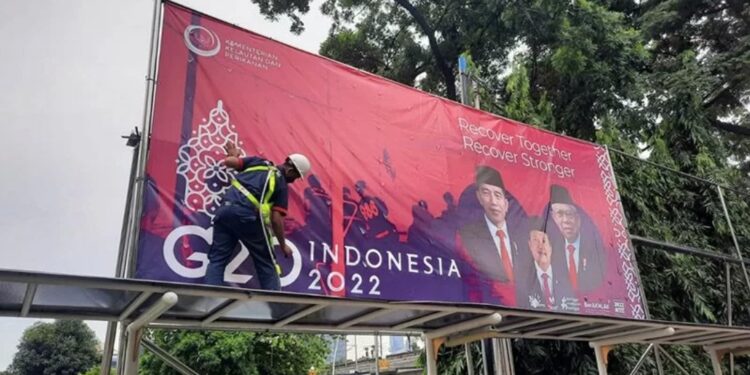 Poster terkait perhelatan internasional G20 dipasang pekerja di sekitar kawasan Kantor Pusat Kementerian Kelautan dan Perikanan di Jakarta. (MASAPNEWS/ANT/HO-KKP)