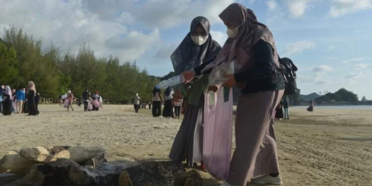Sejumlah mahasiswa bersama Lembaga Swadaya Masyarakat (LSM) Lingkungan, Seulanga Aceh mengumpulkan sampah plastik bekas di pantai wisata Lhoknga, Kabupaten Aceh Besar, Aceh, Senin (21/2/2022). Aksi membersihkan pantai dari sampah plastik bekas di lokasi wisata itu dalam rangka memperingati Hari Peduli Sampah Nasional (HPSN). (MASAPNEWS/ANT)